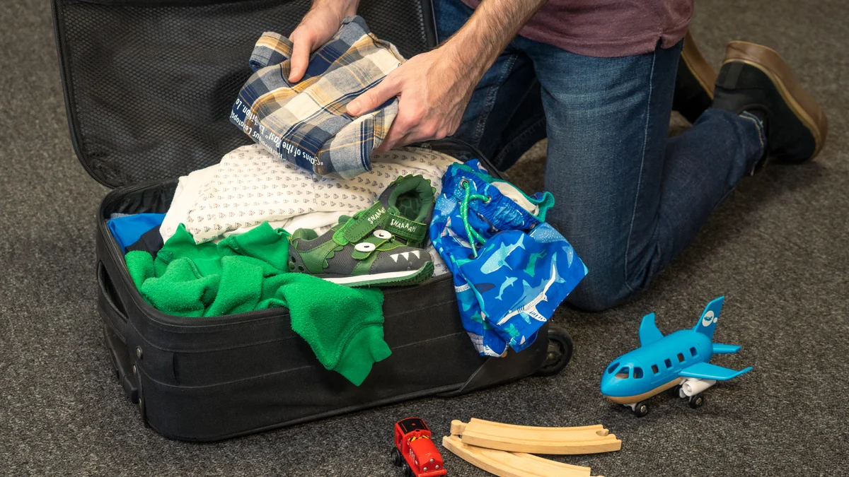 Family packing a suitcase with children's travel items before a China trip