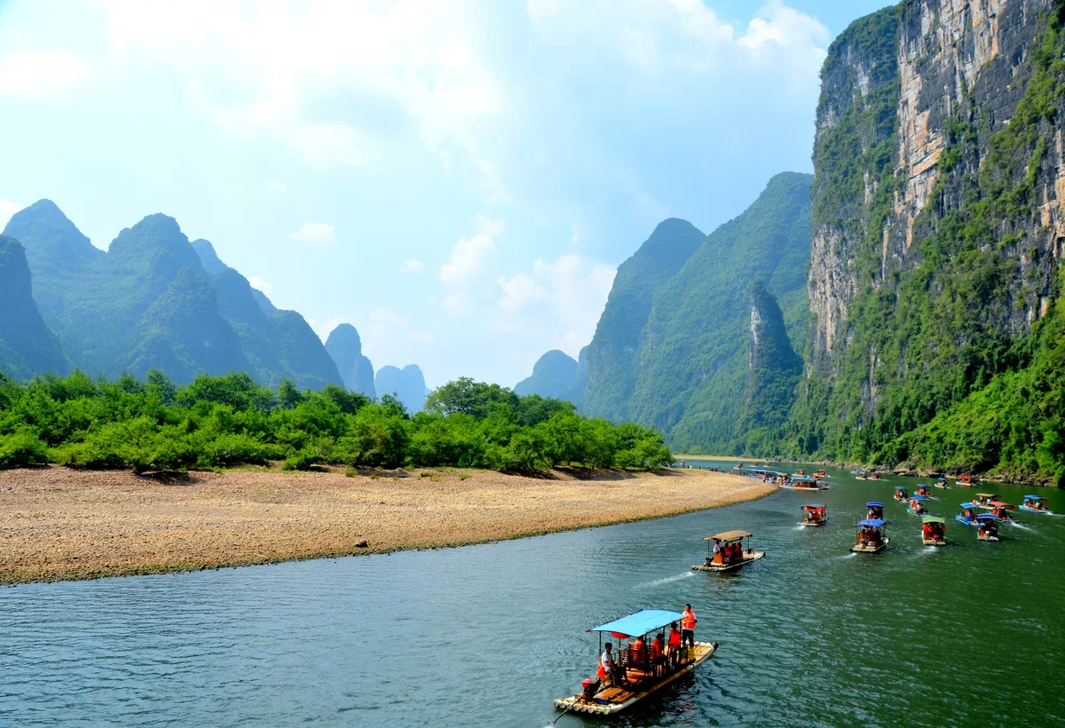 Small boats traveling along the Li River beneath Guilin karst hills