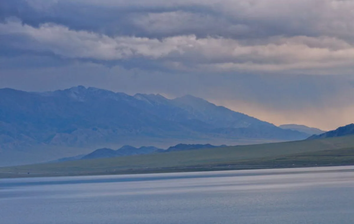 Mountains and blue water at Sayram Lake