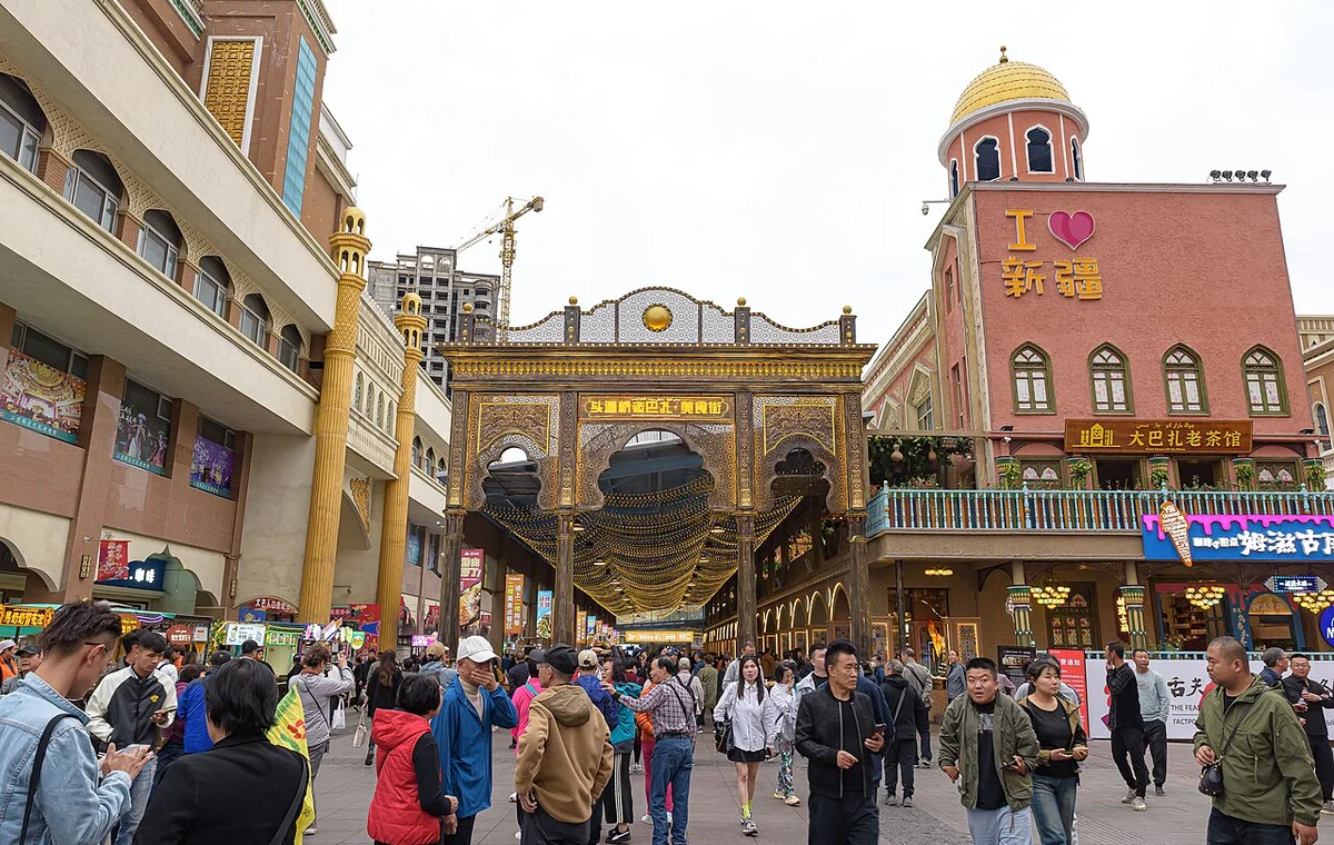 Visitors walking through an Urumqi bazaar street