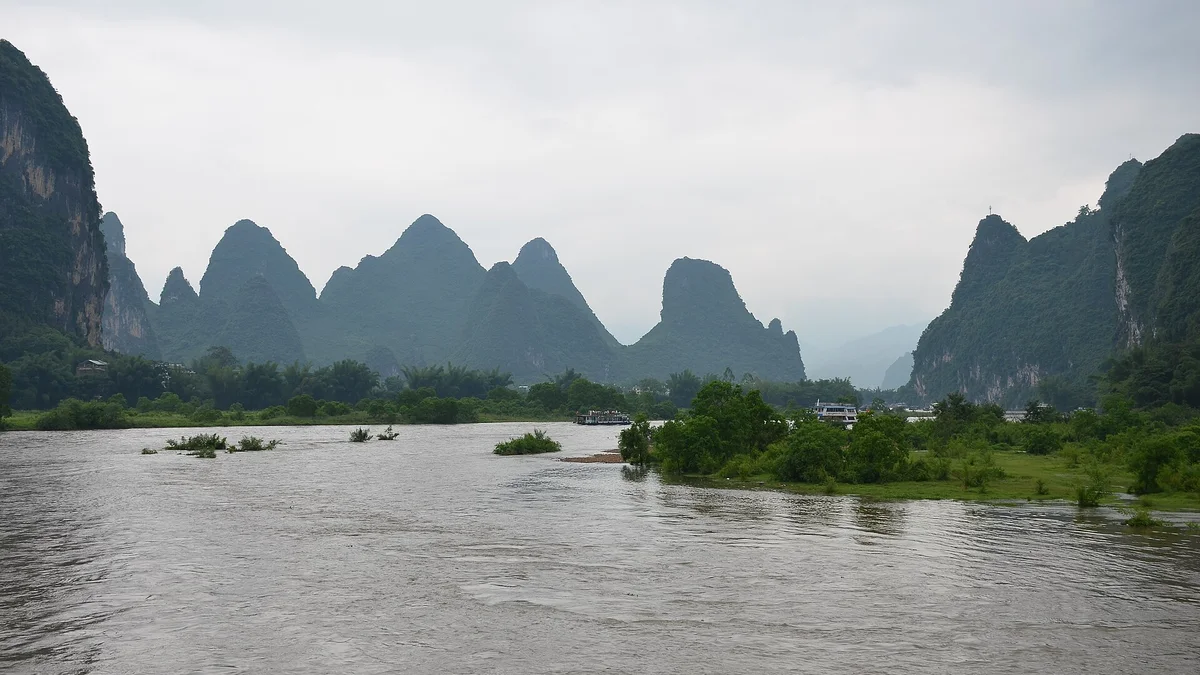 Cruise boats moving along the Li River between Guilin karst hills