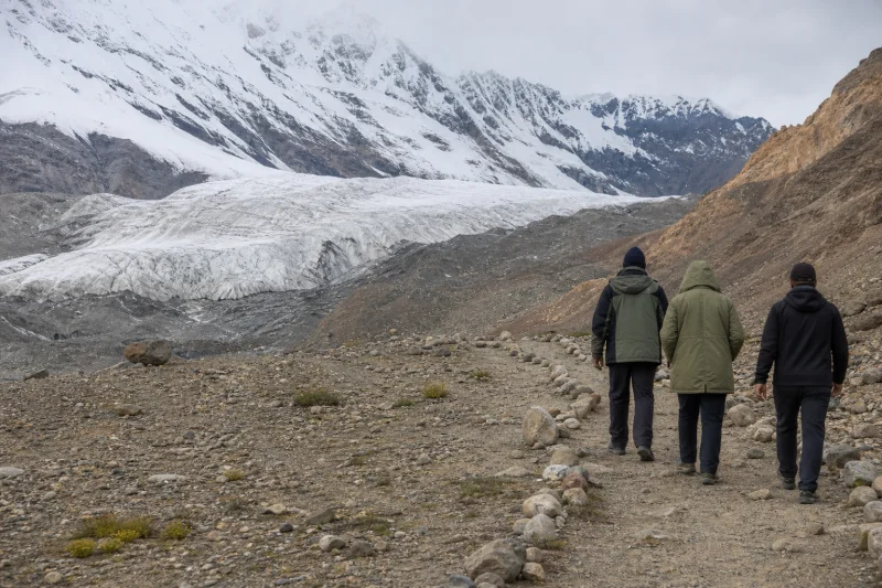 Travelers walking toward a Muztagh glacier viewpoint