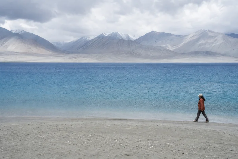 Traveler walking along White Sand Lake in the Pamir region