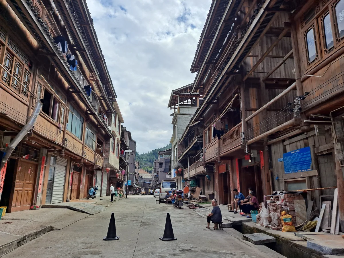 Everyday street scene with timber houses and residents in Dazhai Village